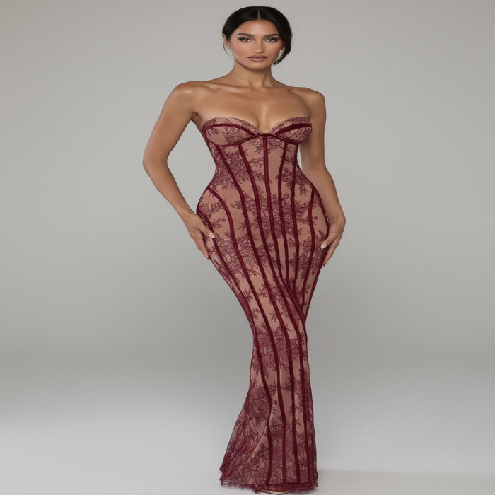 Woman wearing a red lace evening gown against a draped curtain background