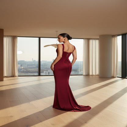 Woman wearing a burgundy evening gown on a light gray background